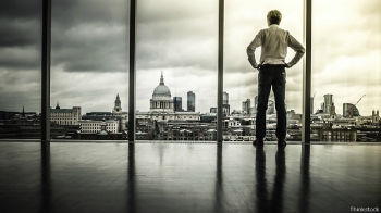 Бизнесмен перед огромным окном с видом на Лондон